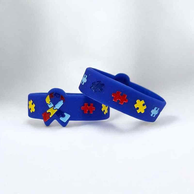 Pulseira de silicone azul com peças de quebra-cabeça coloridas, ideal para conscientização e estilo.